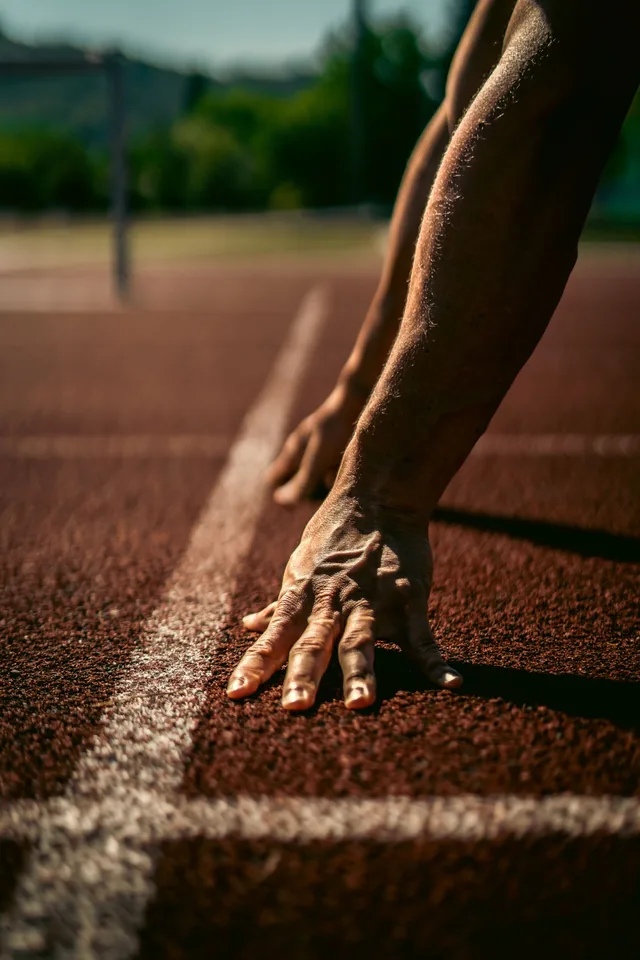 Athlète en position de départ sur une piste, prêt à lancer son sprint